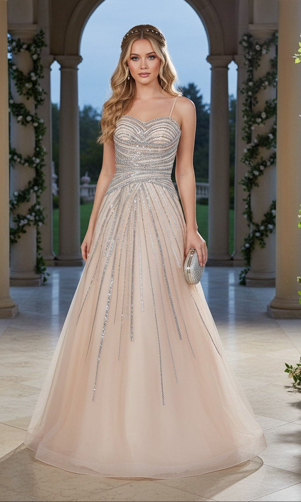 A woman in the champagne Cinderella Couture 8569J long prom dress, featuring sparkling crystal beaded embellishments and an elegant A-line skirt, stands under a colonnade holding a silver clutch with greenery and the evening sky behind her.